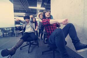 multiethnics business team racing on office chairs photo