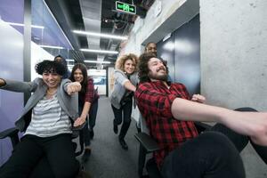 multiethnics business team racing on office chairs photo