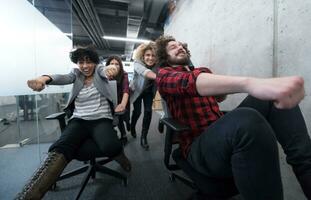 multiethnics business team racing on office chairs photo