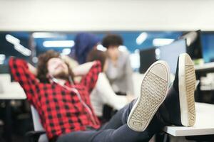 software developer resting with legs on desk photo