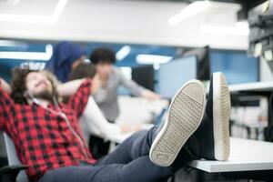 software developer resting with legs on desk photo