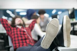 software developer resting with legs on desk photo