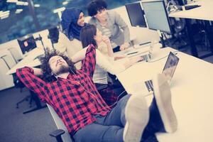 software developer resting with legs on desk photo