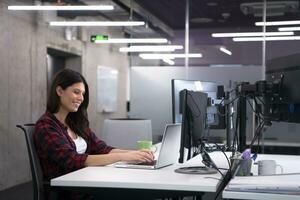 female software developer using laptop computer photo