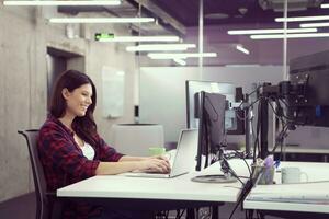female software developer using laptop computer photo
