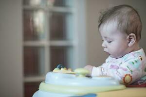 baby learning to walk in walker photo