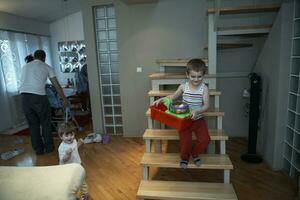 niño pequeño jugando y llevándole juguetes a su hermana foto