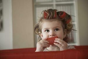 little baby girl with strange hairstyle and curlers photo