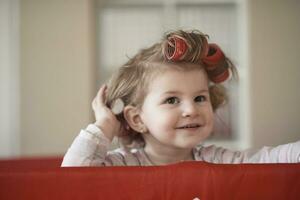 little baby girl with strange hairstyle and curlers photo