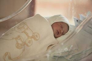 newborn baby sleeping in  bed at hospital photo