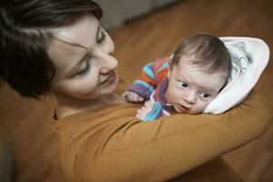 mother is playing with baby at home photo