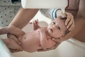 niña recién nacida tomando un baño foto