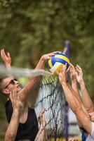 group of young friends playing Beach volleyball photo