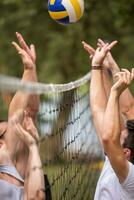 group of young friends playing Beach volleyball photo