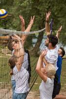 group of young friends playing Beach volleyball photo