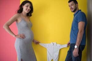 young couple holding baby bodysuits photo