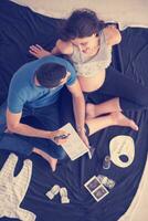 top view of couple checking a list of things for their unborn baby photo