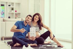 pregnant couple checking a list of things for their unborn baby photo