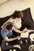 top view of couple checking a list of things for their unborn baby photo