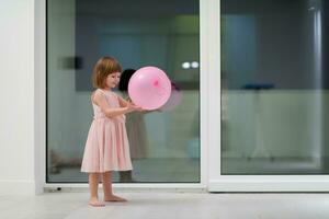 cute little girl playing with balloons photo