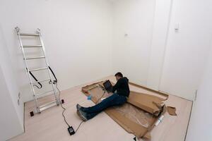 man using laptop while lying on cardboard box photo