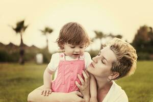 mother and little daughter playing at backyard photo