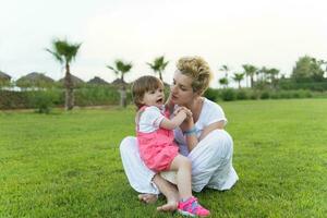 mother and little daughter playing at backyard photo