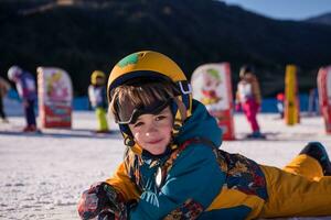 little snowboarder lying on the snow photo