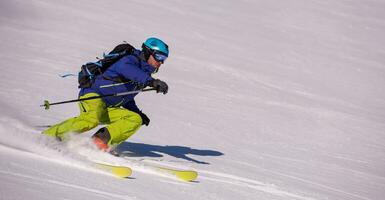 Skier having fun while running downhill photo