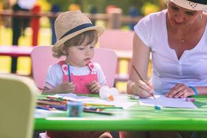 mom and little daughter drawing a colorful pictures photo