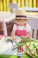 little girl drawing a colorful pictures photo