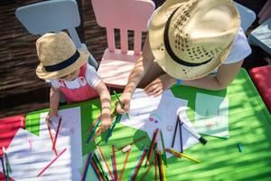 mom and little daughter drawing a colorful pictures photo