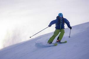 Skier having fun while running downhill photo