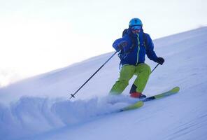 Skier having fun while running downhill photo