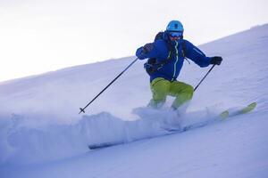 Skier having fun while running downhill photo