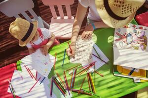 mom and little daughter drawing a colorful pictures photo