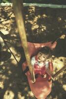 little girl swinging  on a playground photo