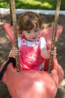 little girl swinging  on a playground photo