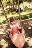 little girl swinging  on a playground photo