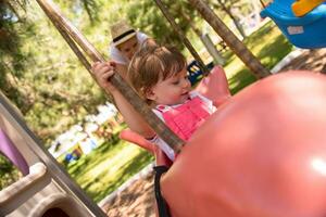 mother and daughter swinging in the park photo