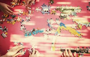 top view of kids hands playing with puzzles photo