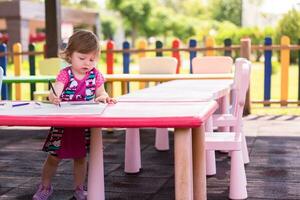 little girl drawing a colorful pictures photo