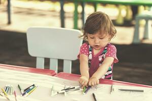 little girl drawing a colorful pictures photo