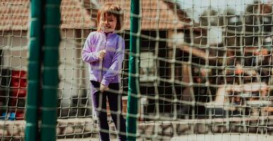 A little girl playing in the park. The concept of family socializing in the park. A girl swings on a swing, plays creative games photo