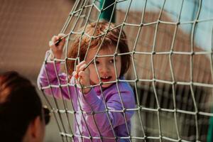 un pequeño niña jugando en el parque. el concepto de familia socializando en el parque. un niña columpios en un balancearse, obras de teatro creativo juegos foto