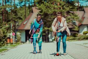 Two women having fun in the park while riding a scooter photo