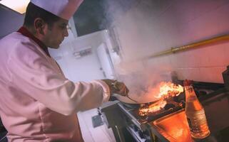 Chef doing flambe on food photo