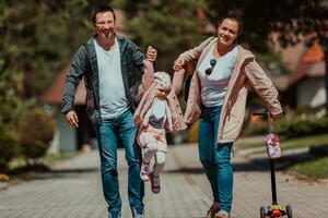 Family fun in the park. Happy family spending time in park and playing with their daughter photo