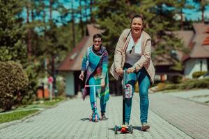 dos mujer teniendo divertido en el parque mientras montando un scooter foto