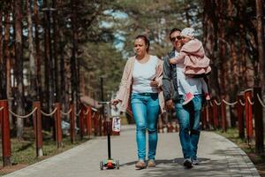 Family fun in the park. Happy family spending time in park and playing with their daughter photo